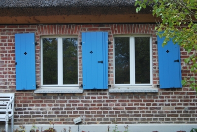 Blaue Klappläden an einem denkmalgeschützen Haus am Stettiner Haff